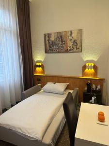 a hotel room with a bed and a table at Hotel Goldenes Lamm in Idstein