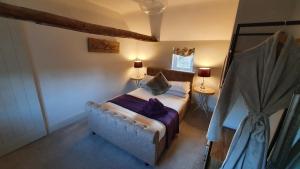 una camera con un letto e due tavoli con lampade di Holly Cottage, Hidden gem in the Yorkshire wolds a Welton
