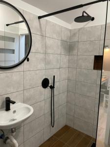 a bathroom with a shower with a sink and a mirror at Apartament Brzóza Królewska in Brzóza Królewska +31 photos