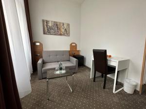 uma sala de estar com um sofá e uma mesa em Hotel Goldenes Lamm em Idstein