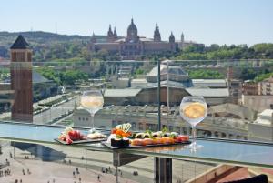 dois pratos de comida e taças de vinho numa saliência em Catalonia Barcelona Plaza em Barcelona