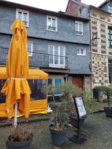 un paraguas amarillo sentado frente a un edificio en Un Brin de folie dans le centre de Honfleur en Honfleur