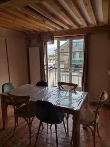 a dining room with a table and chairs and a window at Un Brin de folie dans le centre de Honfleur in Honfleur