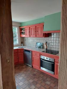 a kitchen with red cabinets and a stove at Un Brin de folie dans le centre de Honfleur in Honfleur