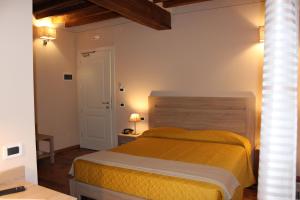 a bedroom with a yellow bed in a room at Albergo Da Ca' Vecia in Spilamberto