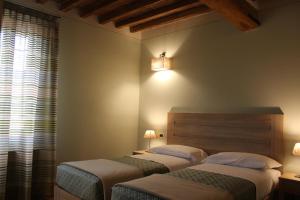 a bedroom with two beds and a window at Albergo Da Ca' Vecia in Spilamberto