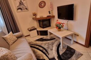 - un salon avec un canapé, une table et une télévision dans l'établissement Casa dei Fiori, à Carlazzo