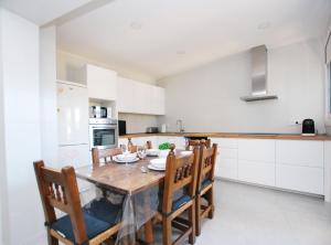 a kitchen with a wooden table and some chairs at La casa del Pi · La casa del Pi · House in the city, next to Barcelona and beach in Badalona