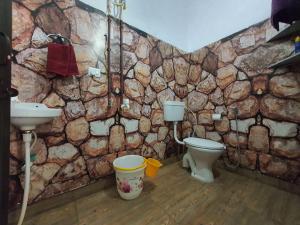 a stone bathroom with a toilet and a sink at Utsav riverbank homestay in Haldwāni