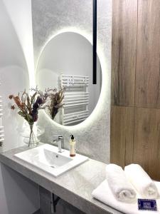 W łazience znajduje się umywalka i lustro. w obiekcie ApartamentCentrum-CHARLOTTE -PARKING- w mieście Bolesławiec