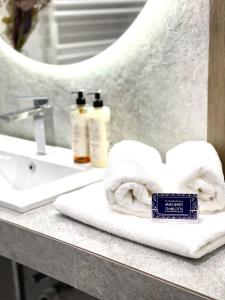 łazienka z ręcznikami, umywalką i lustrem w obiekcie ApartamentCentrum-CHARLOTTE -PARKING- w mieście Bolesławiec