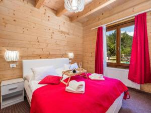 a bedroom with a red bed in a wooden room at Apartments Plitvice forest in Korenica