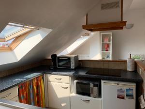 een keuken met een magnetron en een fornuis bij LE CHARME WIMEREUSIEN - lumineux - tout à pied in Wimereux
