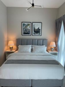 MAG 565, Boulevard, Dubai South, Dubai في دبي: غرفة نوم بسرير ابيض كبير ومصباحين