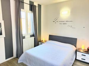 1 dormitorio con cama blanca y ventana en Palazzina Trevigiana 2 king Size Near Station And Venice, en Treviso