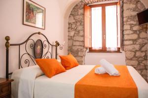 a bedroom with a bed with orange and white sheets at S’ammentu house in Bosa +24 photos