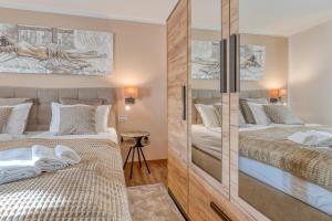 a bedroom with two beds and a mirrored wall at Apartment Nina Pazin in Stari Pazin