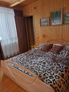 a large bed in a room with wooden walls at Котедж "Хата Рибака" in Kosiv