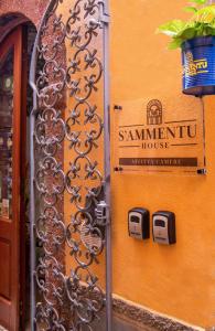 un cartello sul lato di un edificio di S’ammentu house a Bosa