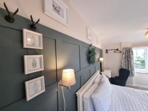 a bedroom with a bed and a wall with pictures at Burnside Cottage in Sleights