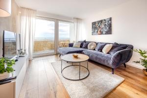 ein Wohnzimmer mit einem Sofa und einem Tisch in der Unterkunft Moderne 2-Zimmer-Wohnung mit atemberaubender Skyline Aussicht auf Frankfurt! in Steinbach im Taunus