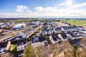 una vista aérea de una pequeña ciudad con casas en Moderne 2-Zimmer-Wohnung mit atemberaubender Skyline Aussicht auf Frankfurt! en Steinbach im Taunus