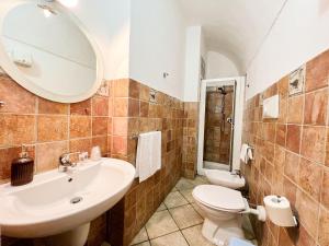 bagno con lavandino, servizi igienici e specchio di S’ammentu house a Bosa