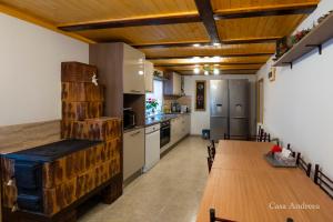 a kitchen with wooden ceilings and a wooden table with a dining room at Casa Andreea in Broşteni