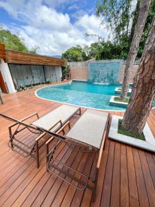 a deck with two chairs and a swimming pool at Hotel Aromas de Penedo in Penedo