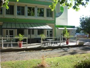 un bâtiment avec un banc et une table devant lui dans l'établissement West Appart' Hôtel, à Bessines