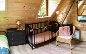 a room with a crib and a chair in a cabin at Dom Farmerski w Górach Stołowych in Radków