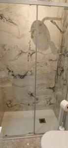 a shower with a glass door in a bathroom at La Buona Stella Apartment in Pistoia