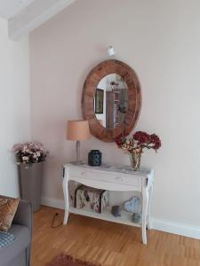 einen weißen Tisch mit einem Spiegel an der Wand in der Unterkunft Elegant house with a garden in Mira