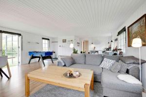 uma sala de estar com um sofá e uma mesa em Nyistandsat sommerhus med kærlighed og sjæl em Kyndeløse