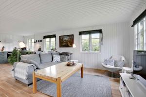uma sala de estar com um sofá e uma mesa em Nyistandsat sommerhus med kærlighed og sjæl em Kyndeløse