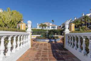 une clôture blanche avec une passerelle en briques dans l'établissement 042 Classic 2 Bed Andalusian Townhouse 500m From Beach, à Mijas