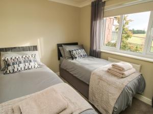 a bedroom with two beds and a window at The Marshes in Welshpool