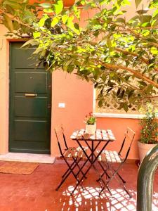 uma mesa e cadeiras em frente a uma porta verde em Casa con giardinetto al centro di Roma em Roma