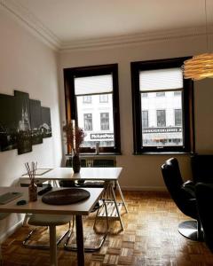 een woonkamer met 2 tafels en 2 ramen bij EXKLUSIVE Wohnung mitten im schönsten Viertel in Bremen