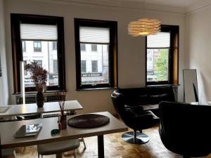een woonkamer met een tafel, stoelen en ramen bij EXKLUSIVE Wohnung mitten im schönsten Viertel in Bremen