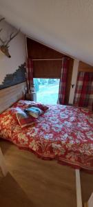 1 dormitorio con 1 cama con edredón rojo y ventana en Bal2502, en Manigod