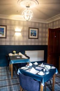 a dining room with two tables and a chandelier at Kintrae B&B in Buckie