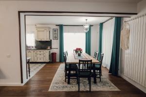 a dining room with a table and chairs at Pensiunea Magnesia (4 margarete****) in Sânâteşti