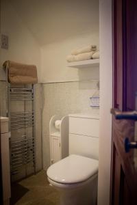 a bathroom with a toilet and towels on a shelf at Kintrae B&B in Buckie
