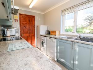 a kitchen with a washing machine and a sink at Salakee in Penzance +17 photos