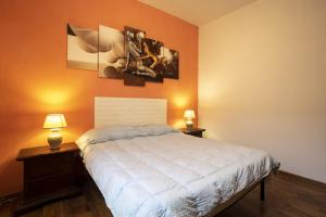 1 dormitorio con 1 cama con 2 lámparas y cuadros en la pared en Ginevra Vista Mare, en Campobello di Mazara