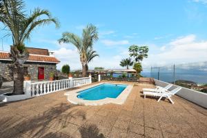 uma casa com uma piscina e uma cadeira branca em Finca Viña Maria em Los Realejos