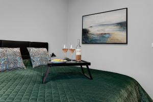 un letto con un tavolo e bicchieri da vino sopra di B20 Apartments a Reykjavik