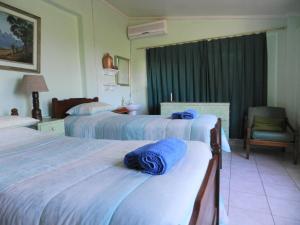 a hotel room with two beds with blue towels on them at Dinizulu Cottage in Hluhluwe