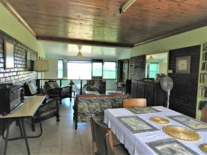 a living room with a table and a dining room at Dinizulu Cottage in Hluhluwe
